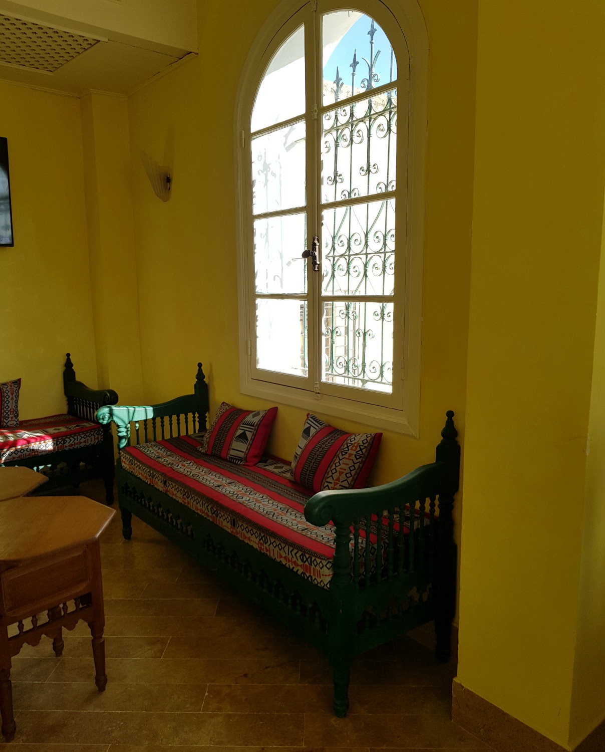 Striped sofas in the tea house at Palais Bayram, with shisha piles and a TV
