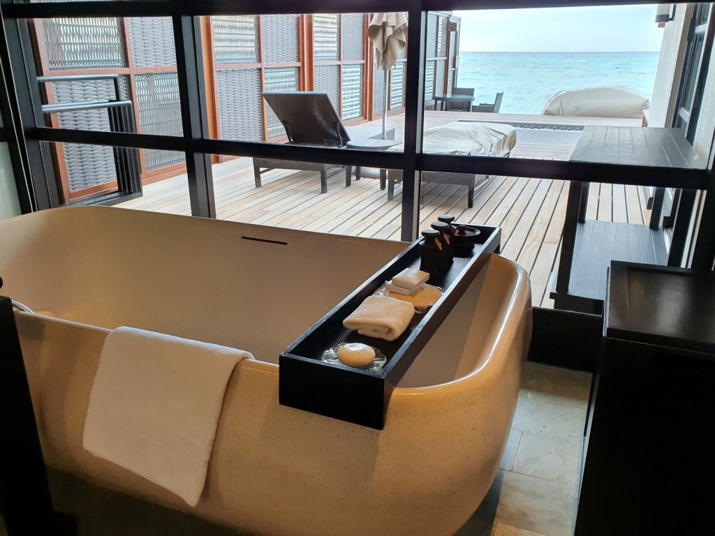 Bath tub looking out to the deck and Indian ocean in our water villa at Four Seasons Kuda Huraa with kids