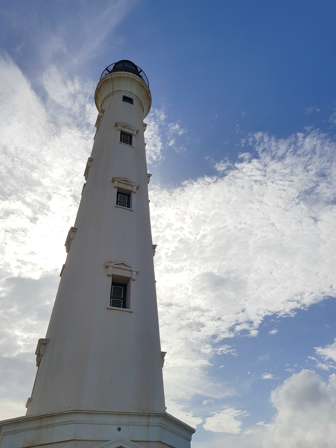The California lighthouse on Aruba's northernmost tip, against a blue sky - if you visit Aruba with kids, older ones will enjoy the views from the top