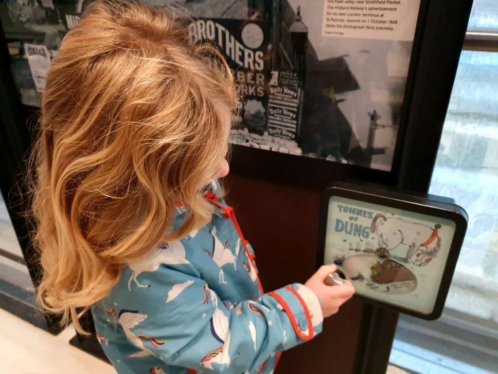 My daughter with one of the interactive displays showing how much dung London's horse-drawn transport produced