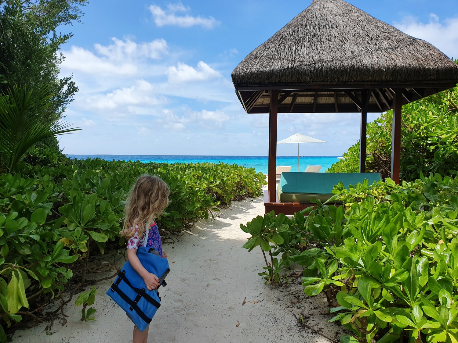 My daughter with her life vest on the sandy path leading to the beach and snorkel trail, with the Indian Ocean on the horizon - one of the highlights of a stay at Landaa Giraavaru resort in the Maldives