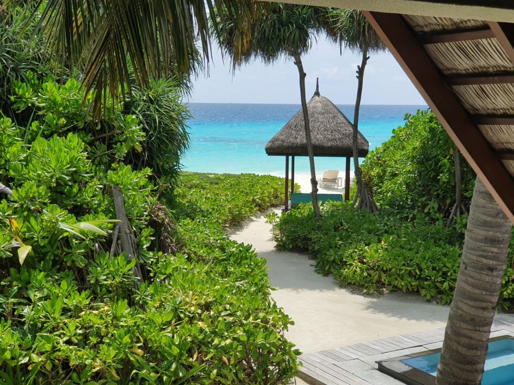 Path leading to the beach and a day bed on the sand from our beach villa at Landaa Giraavaru in the Maldives