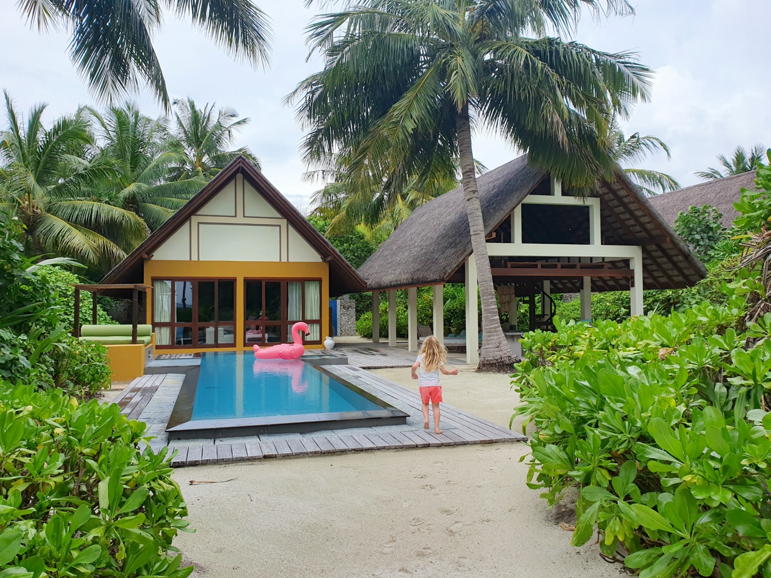 View of my daughter walking from the beach path towards our beach villa, with its private pool and covered lounger area at Landaa Giraavaru resort in the Maldives