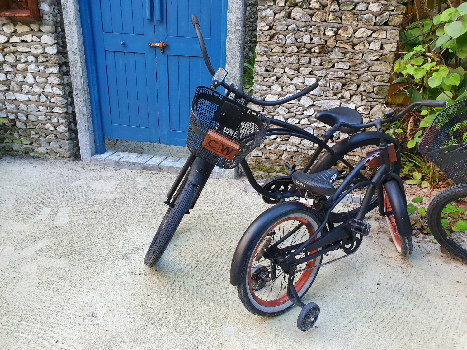 Bikes outside the door leading to our beach villa at Landaa Giraavaru resort in the Maldives, with stabilisers on my daughter's bike and my initials showing on mine