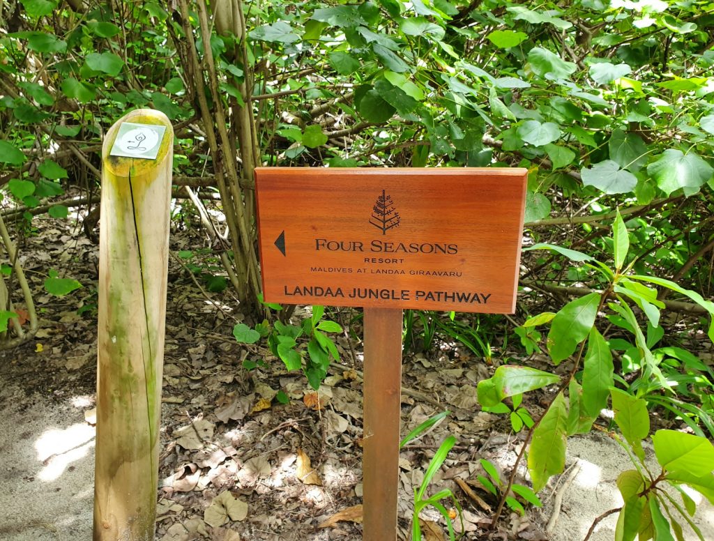 Sign pointing to the jungle path running through the heart of Landaa Giraavaru resort in the Maldives