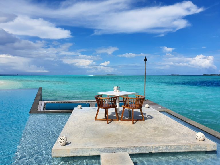 Table by the pool and looking out onto the turquoise Indian Ocean - my review of Four Seasons Maldives Landaa Giraavaru with kids