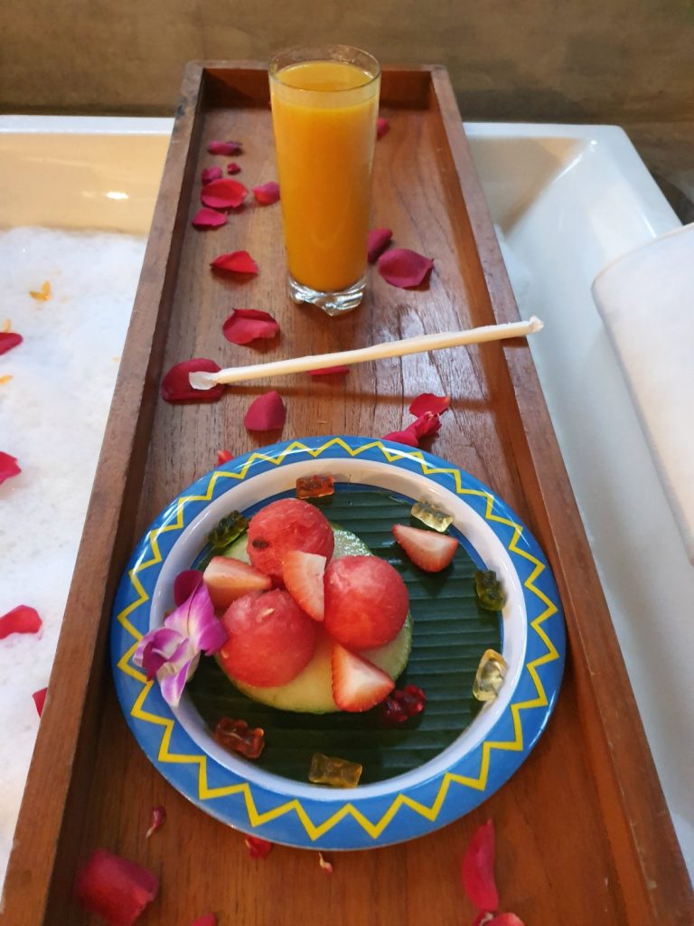 Tray over the bath with fresh fruit and mango juice for my daughter at Landaa Giraavaru resort in the Maldives