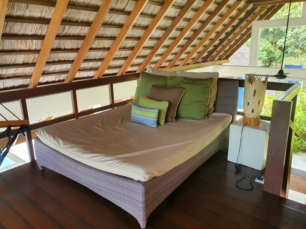 Day bed on the balcony above the lounger area of our beach villa at Landaa Giraavaru resort in the Maldives, looking out to the hammock and the ocean