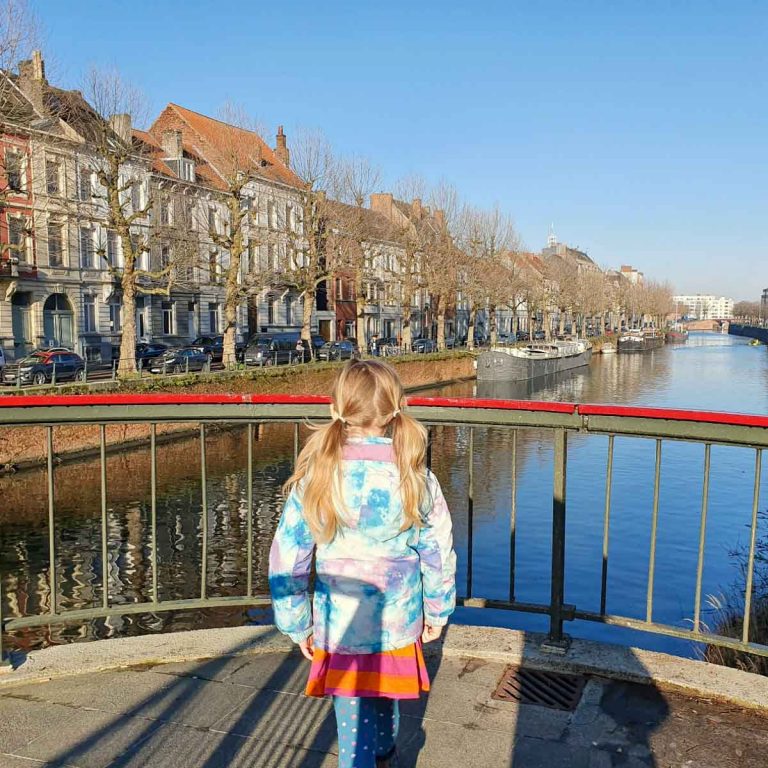 My daughter stands looking out onto a canal in Ghent, Belgium - on our city break, we discovered some of the best things to do in Ghent with kids