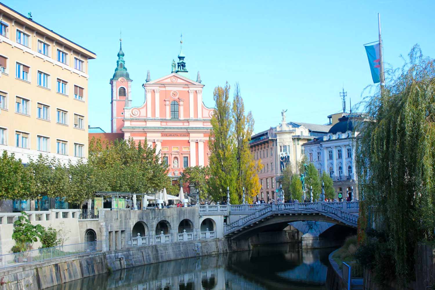 View of the pink church and other buildings by the river in Slovenia's capital Ljubljana - my top advice for Ljubljana city breaks