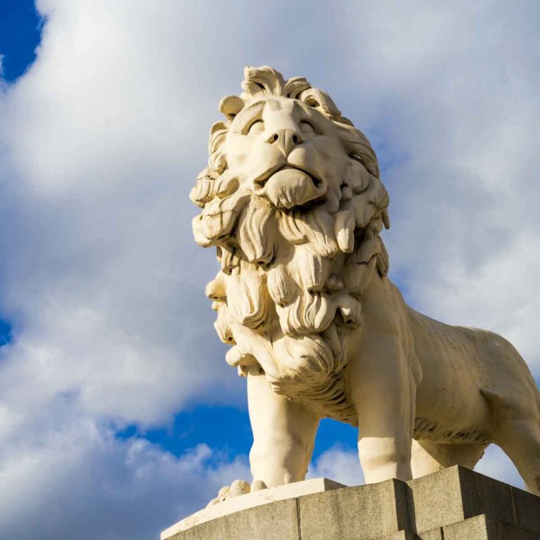 A lion statue in London against a blue sky - one day in London with kids who love animals, my ideas for animal-loving kids if you've only got a short time to explore