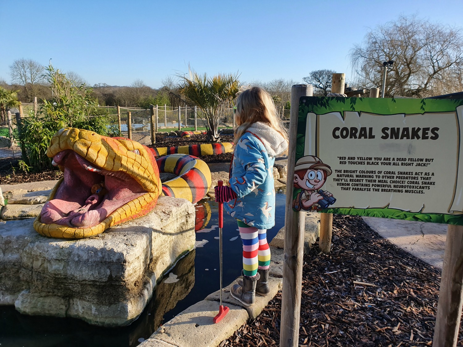 My daughter by a statue of a snake in the Congo course at Lost Jungle London - visiting Lost Jungle adventure golf, Europe's biggest adventure golf course