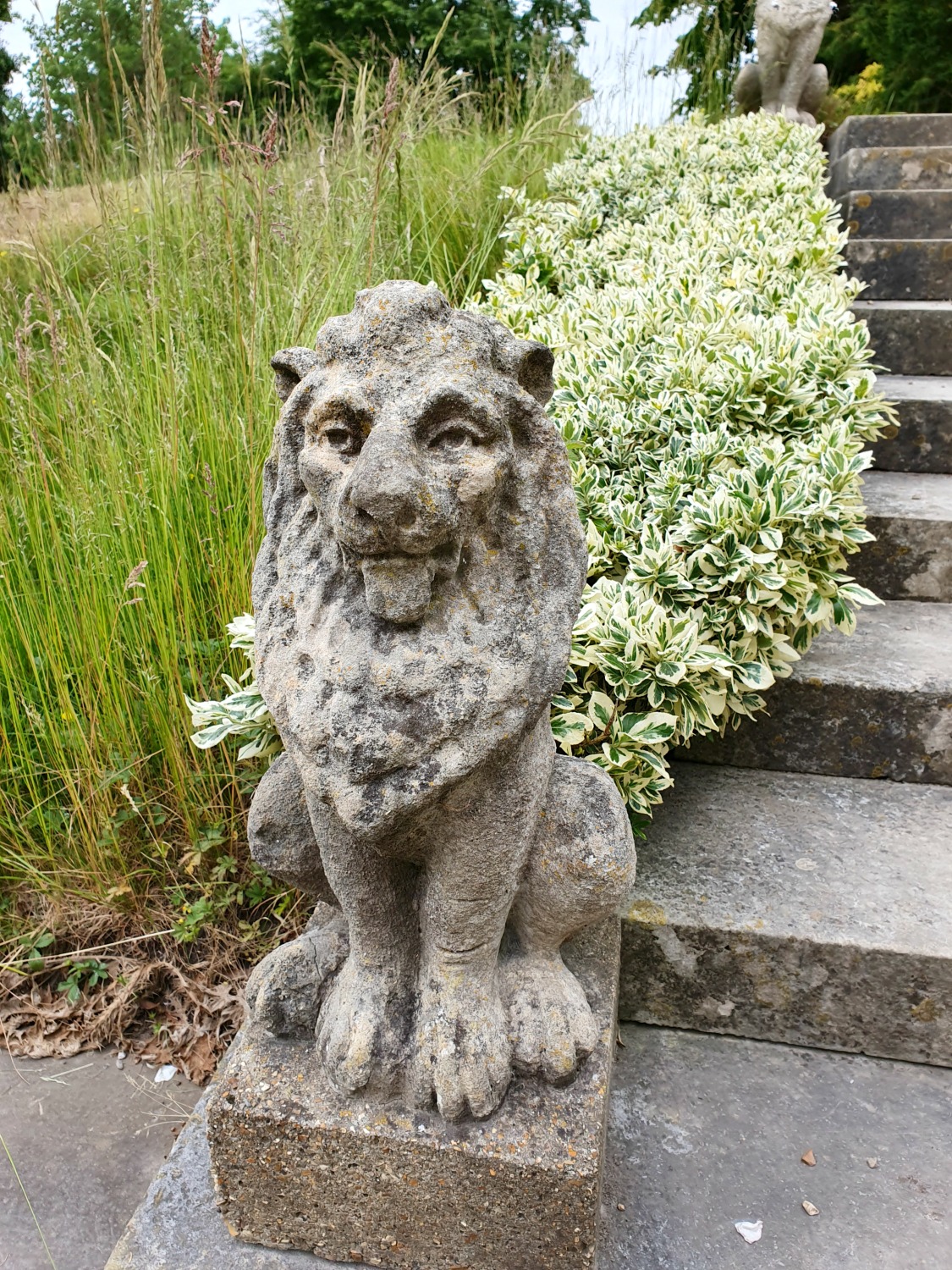 Stone lion at the bottom of steps near the house at Polesden Lacey
