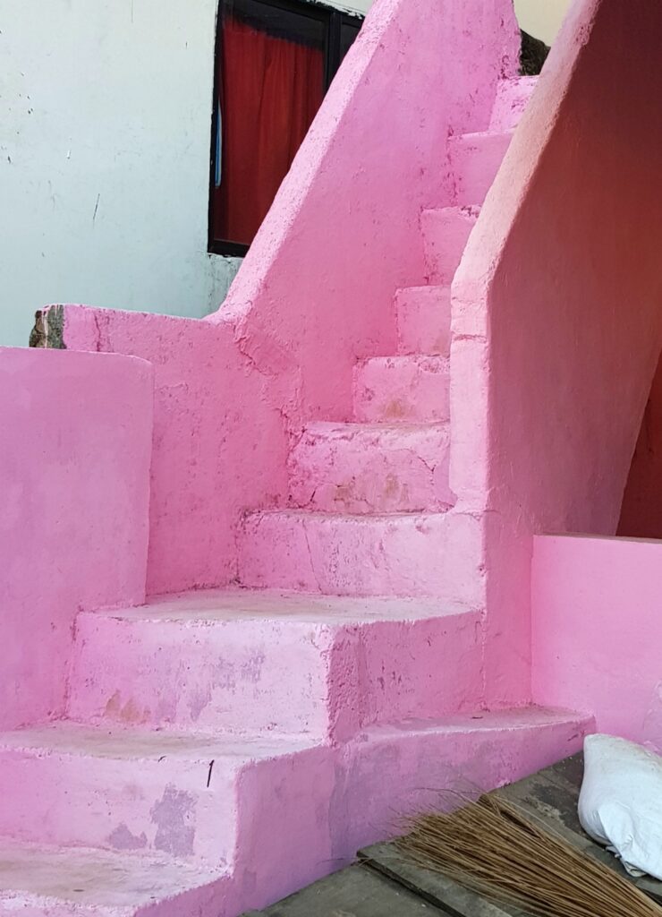 A bright pink staircase in Munnar, vibrant against the white walls of the houses - the vibrant colours are one of my reasons to visit Kerala