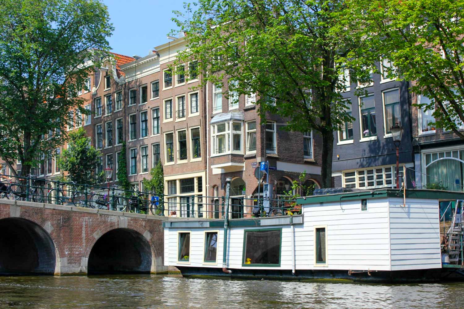 Houseboat by a typical Amsterdam bridge and canal - canal boat tours are included in the I Amsterdam card. Is the I amsterdam card worth it? My review