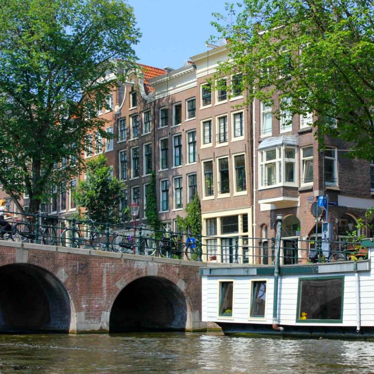 Houseboat by a typical Amsterdam bridge and canal - canal boat tours are included in the I Amsterdam card. Is the I amsterdam card worth it? My review