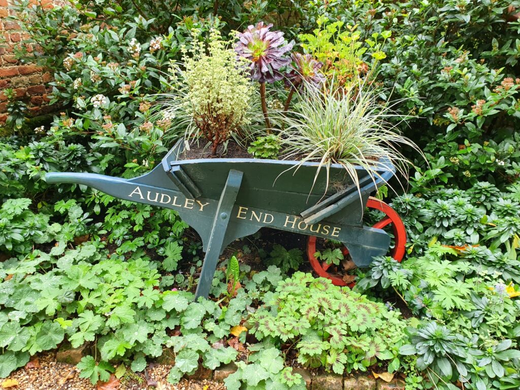 Plants growing in a wheelbarrow at the entrance to the walled garden at Audley End during a weekend in Essex with kids