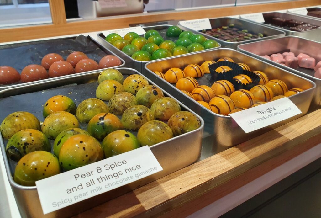 Boxes of individual chocolates in different colours, including spiced pear and ones using local honey at Hill Street chocolate in Essex, unmissable if you're visiting Saffron Walden with kids