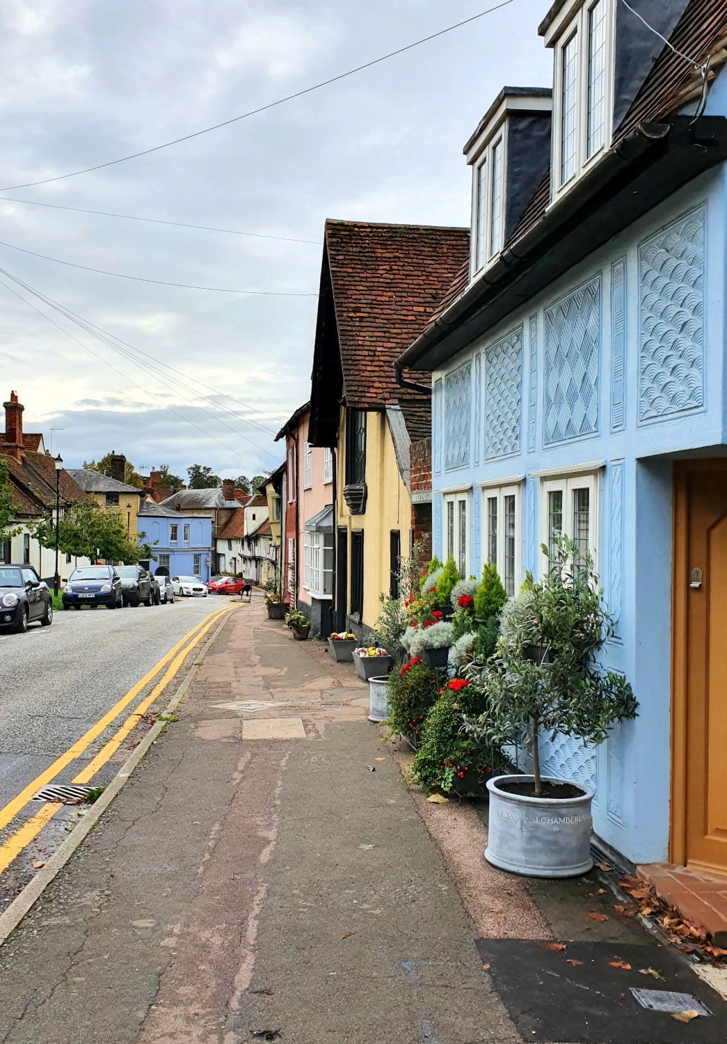 View of the historic houses lining Castle Street in Saffron Walden, in different pastel shades including blue and yellow - visiting the Fry art gallery near here is one of several things to do during a weekend in Saffron Walden with kids