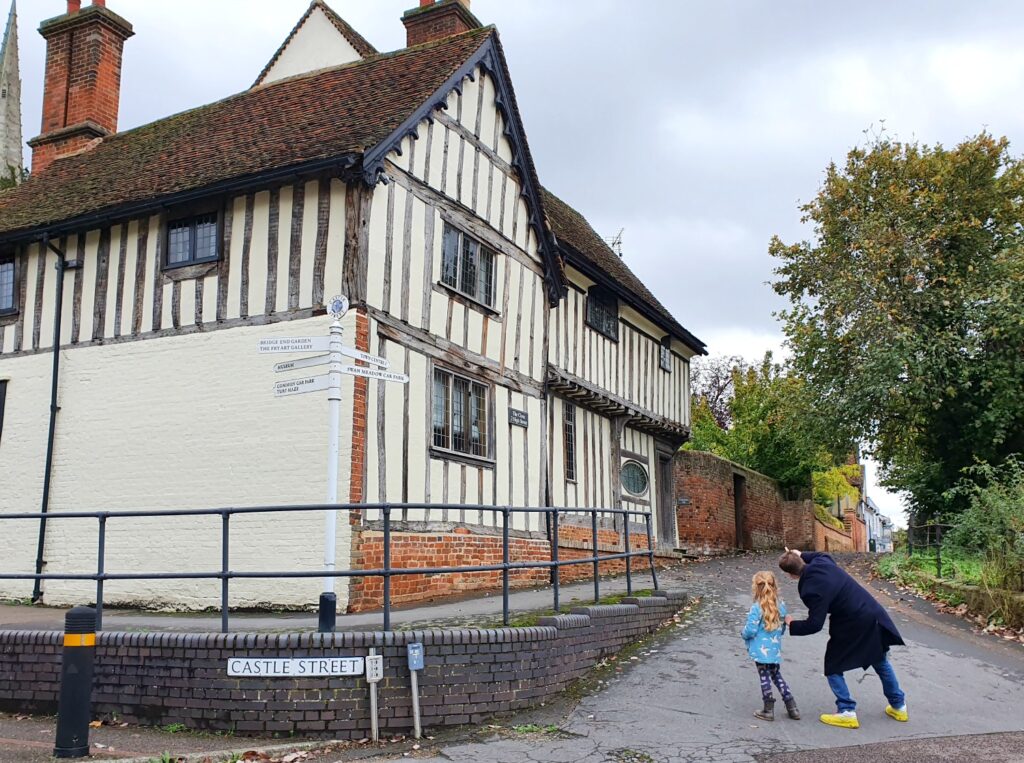 My husband and daughter look up at Myddylton Place, a historic house on the Saffron Walden town trail, if you're visiting Essex with kids