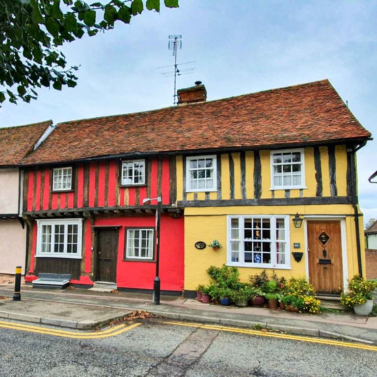 Red, pink and yellow historic houses lining a street in Saffron Walden in Essex