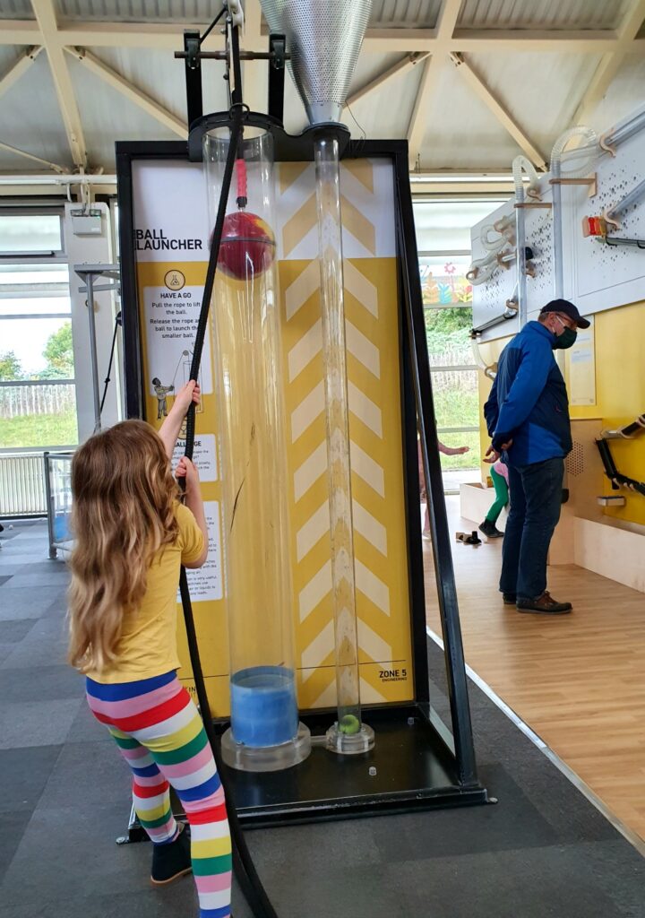 My daughter pulling on a rope attached to a ball to show the force of compressed air at Winchester Science Centre - my review