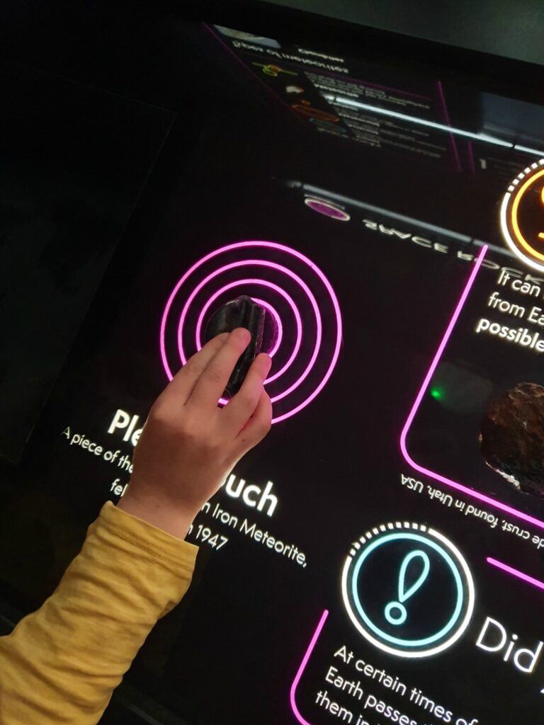 My daughter strokes a meteorite in the space gallery at Winchester Science Centre - my review