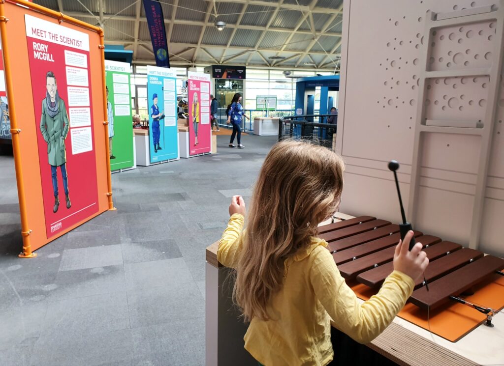 My daughter plays a wooden xylophone as part of the displays on sound at Winchester Science Centre - my Winchester Science Centre review