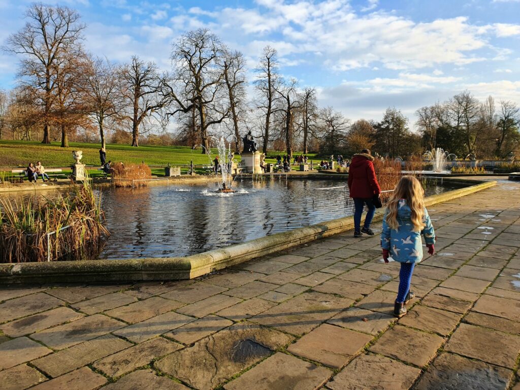 My daughter walks around the fountains in the Italian Gardens at Kensington Gardens