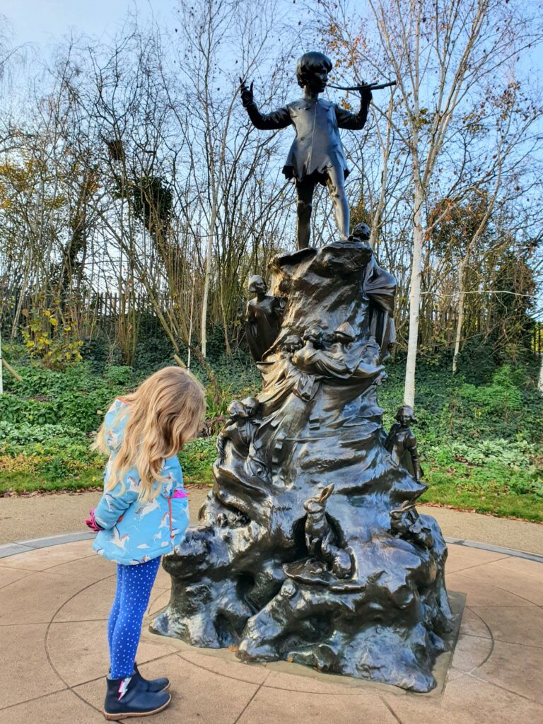 My daughter looks at the Peter Pan statue in Kensington Gardens
