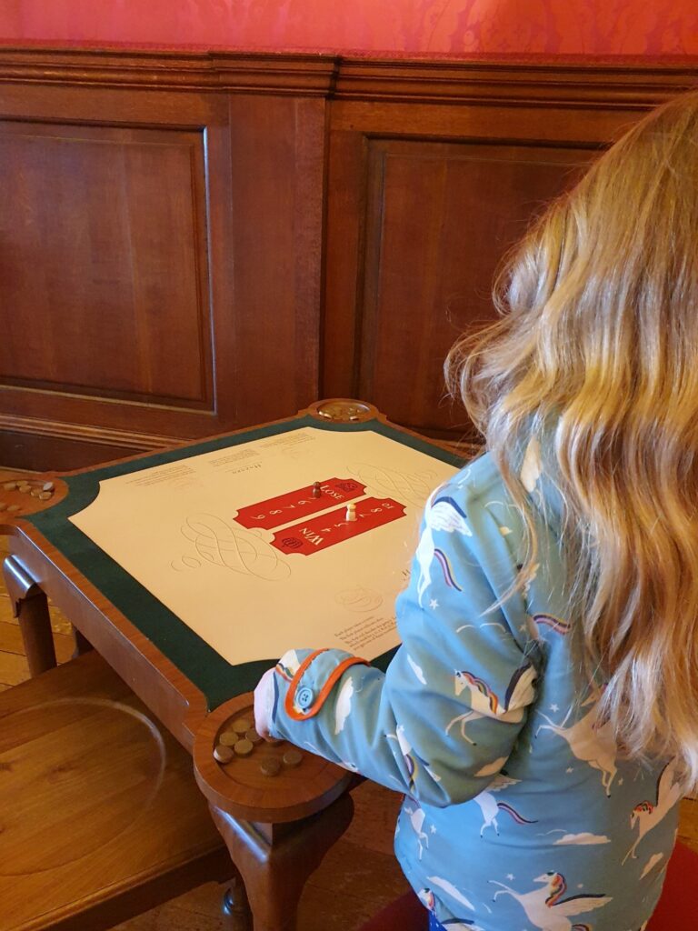 My daughter looks at a gaming table for 18th century dice game Hazard at Kensington Palace