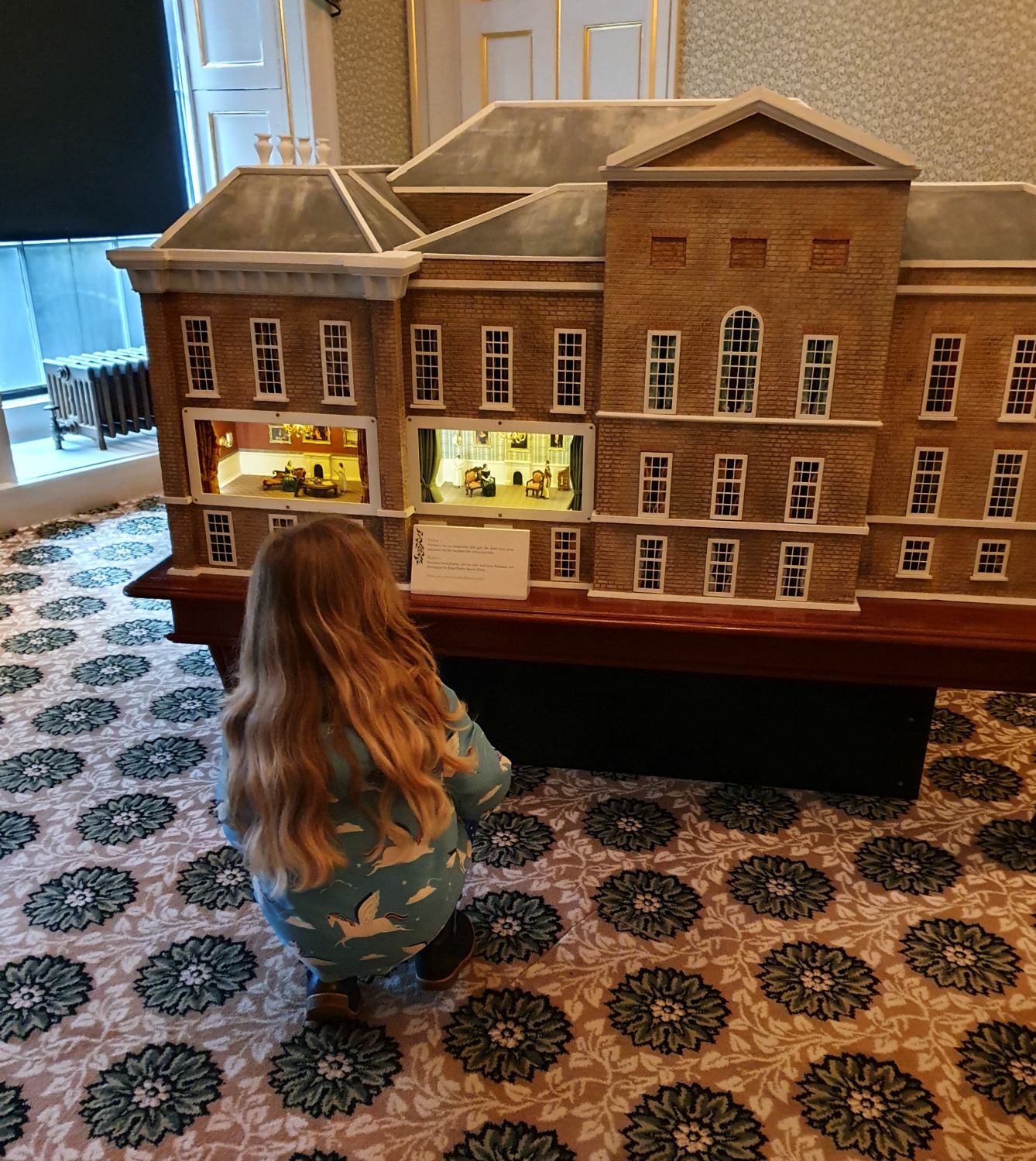 My daughter looks at a model of Kensington Palace illustrating scenes from Queen Victoria's childhood 
