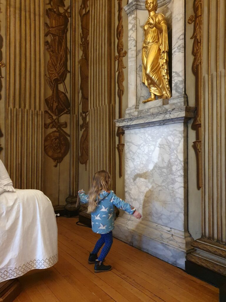 My daughter dances with a shadow figure in one of the ornate rooms at Kensington Palace