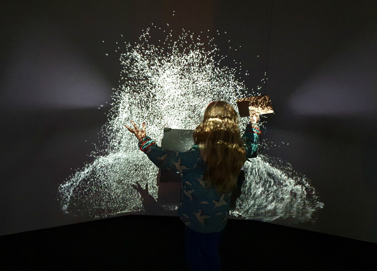 My daughter pretends to conjure light from a suitcase in a light display at the end of the Fantastic Beasts exhibition at the Natural History Museum in London - one of the highlights of our 2020 family travel