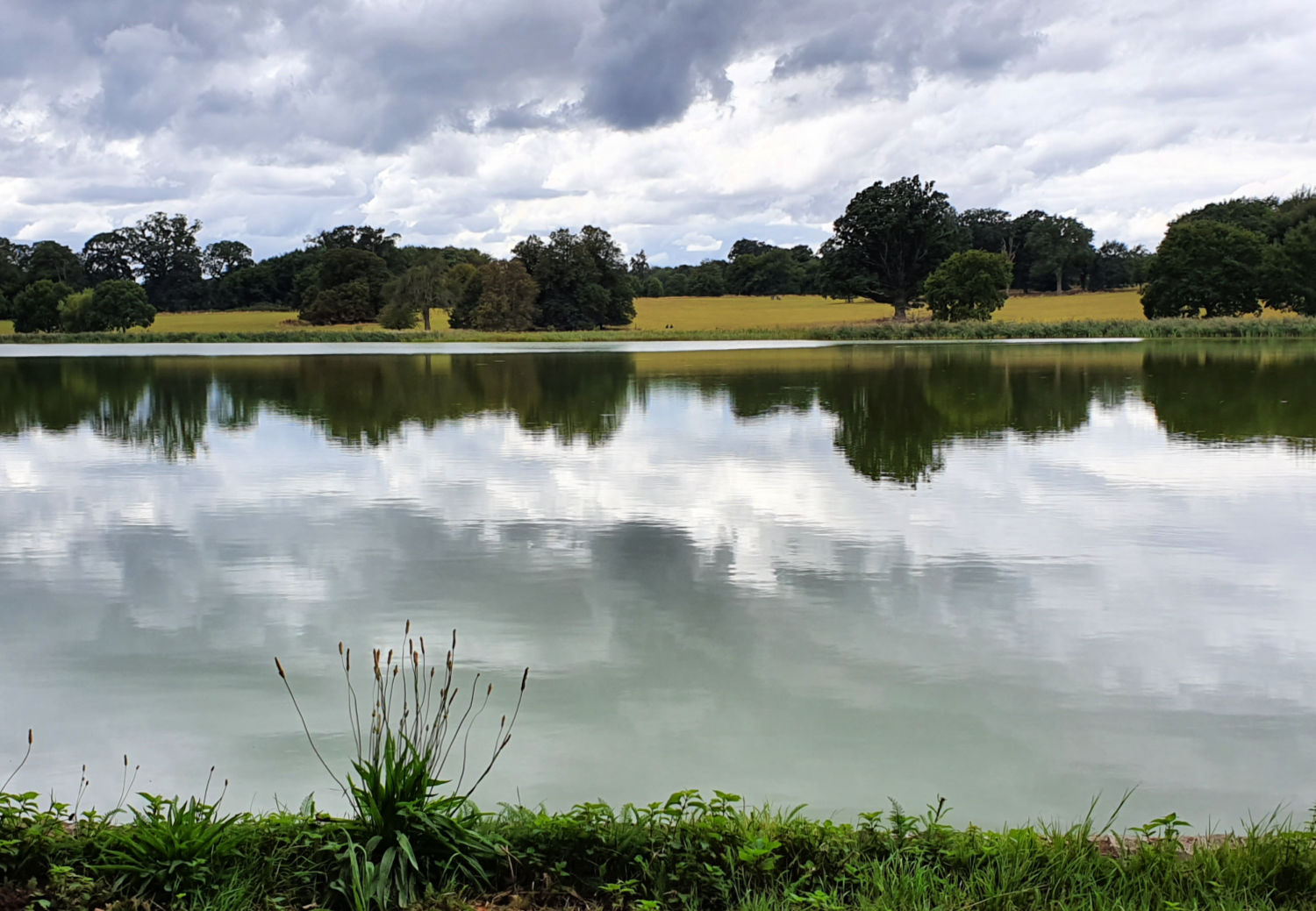 A view across the lake at Blickling Hall near Norwich with the clouds reflected in the water - a visit to Blickling Hall with kids
