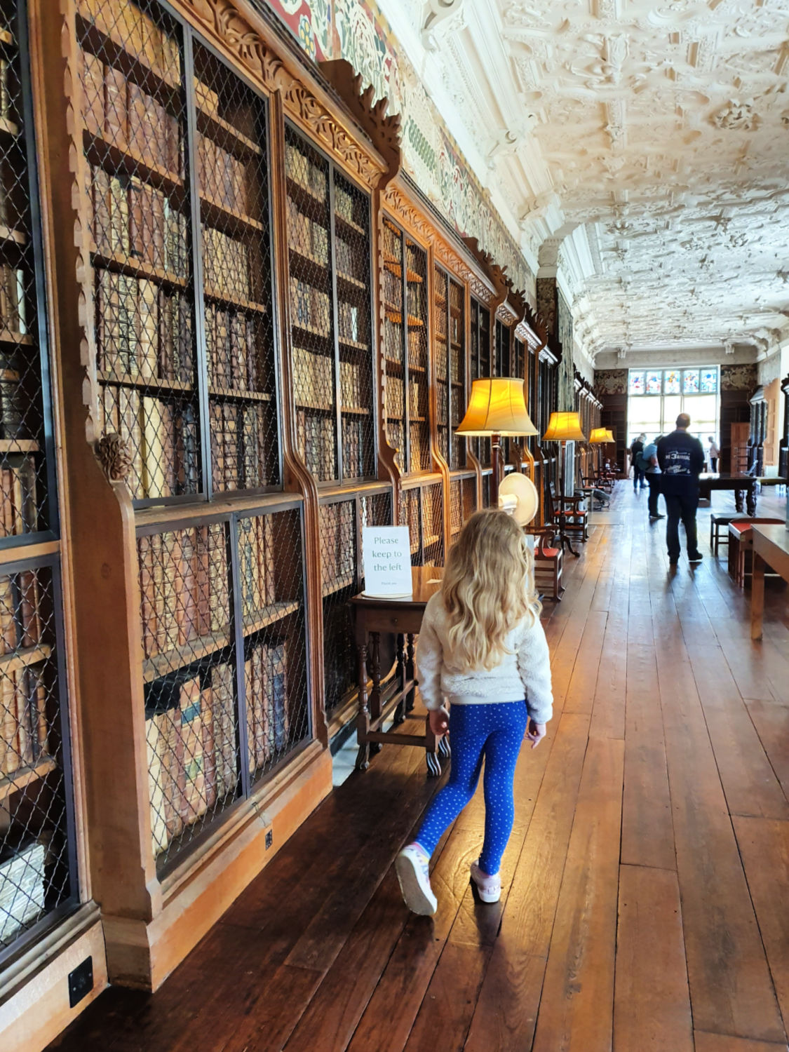 My daughter walks through the long library at Blickling Hall near Norwich - a day out at Blickling Hall with kids