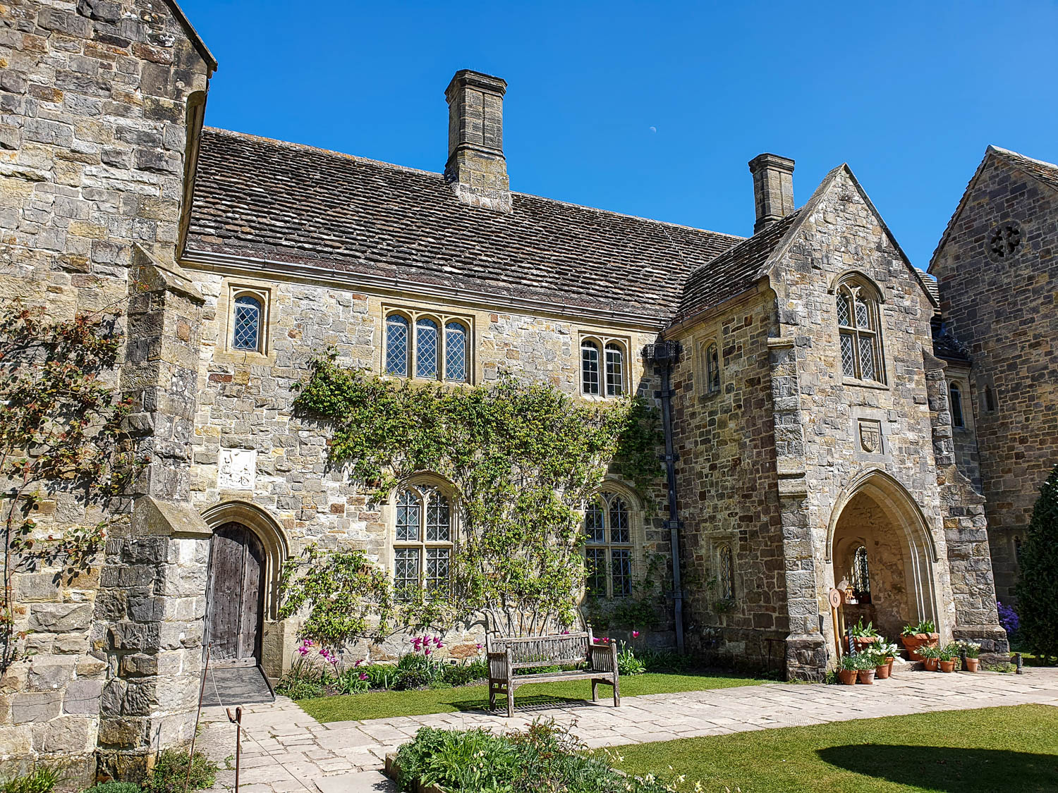 The front view of the old house of Nymans in Sussex in the sunshine - a day out at Nymans with kids
