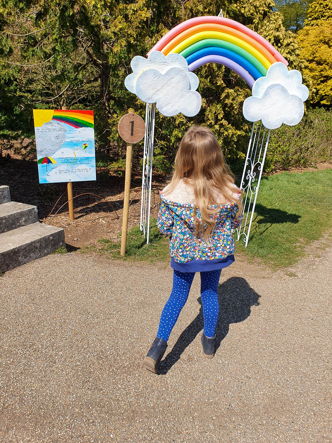 My daughter looks at a rainbow at the start of the Easter trail at Nymans in Sussex - a day out at Nymans with kids