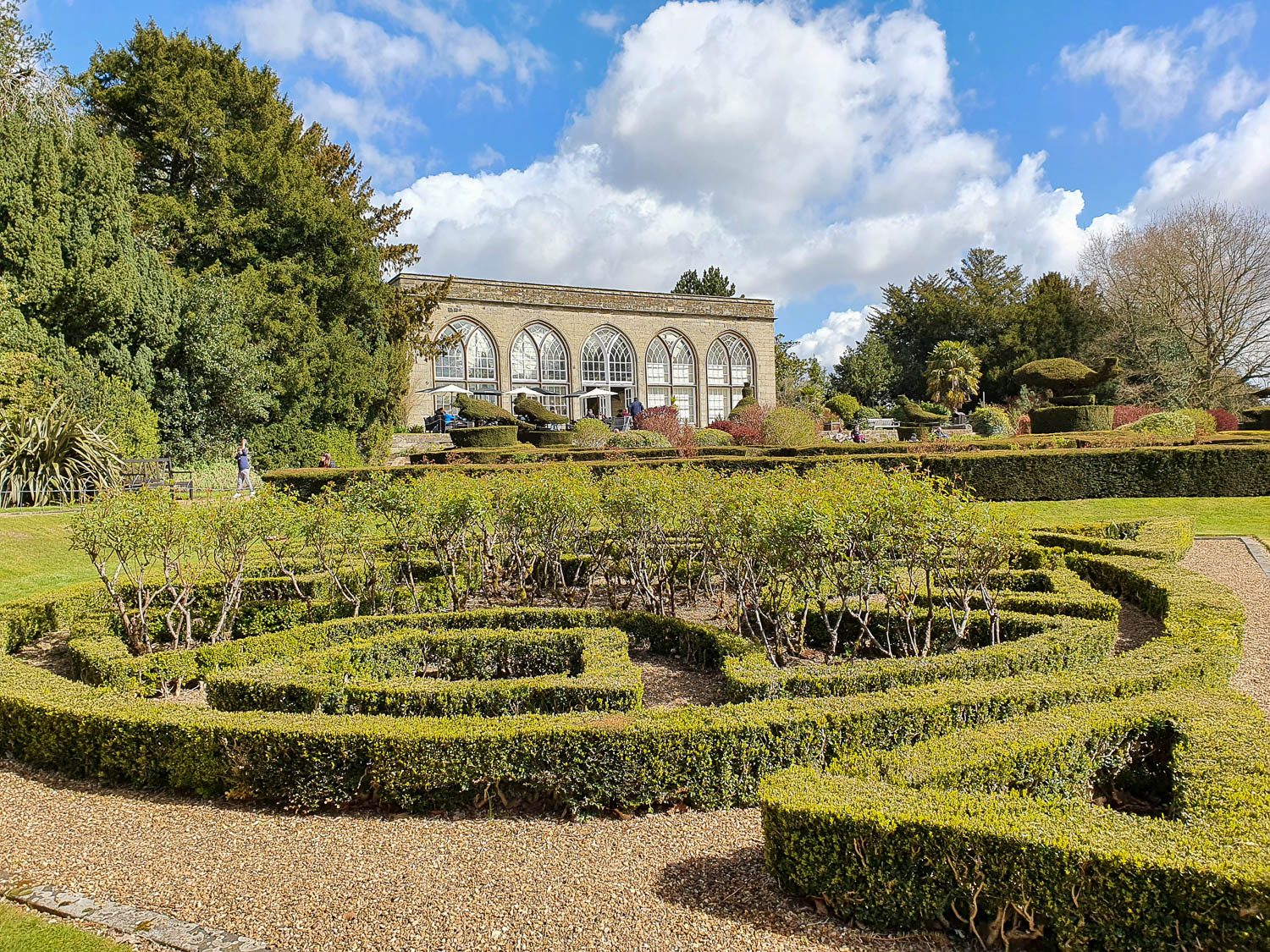 View across the formal gardens to the cafe in the peacock garden at Warwick Castle on a sunny spring day