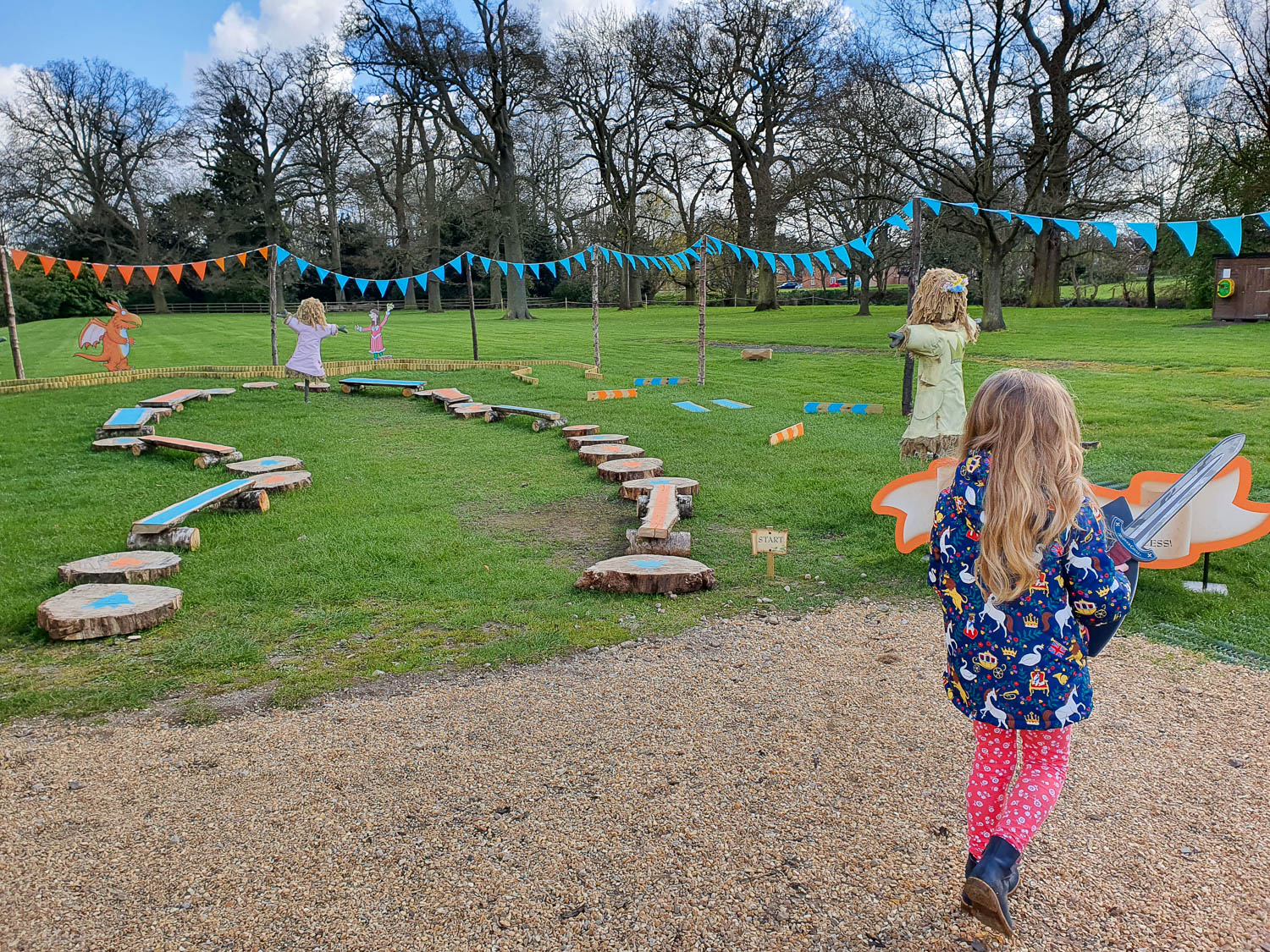 My daughter holds her toy sword as she looks at the princess scarecrows and activity course on the Zog trail at Warwick Castle - my review of the Warwick Castle Zog trail