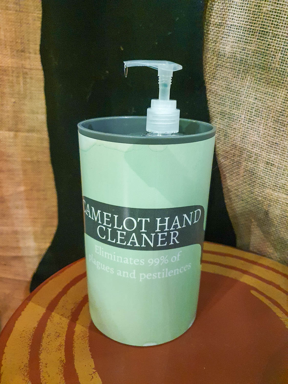 Green bottle of hand sanitiser marked Camelot Hand Cleaner, part of the interactive exhibit around the Sword in the Stone in the Whispering Wood at the Oxford Story Museum