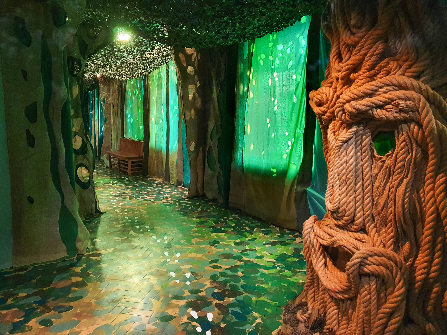 View of the entrance to the Whispering Wood with a tree face made of rope, and hare paw prints leading across the floor - my Oxford Story Museum review