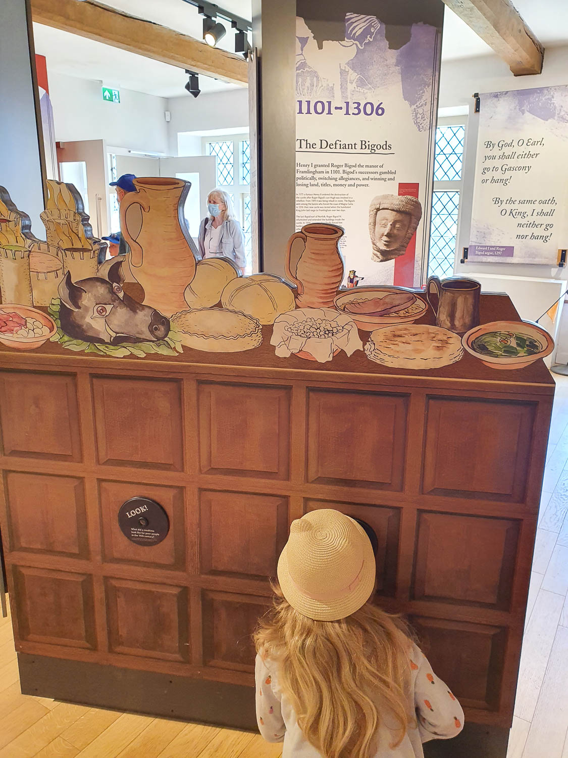 My daughter looks at one of the displays about the history of Framlingham Castle during a day out in Suffolk with kids