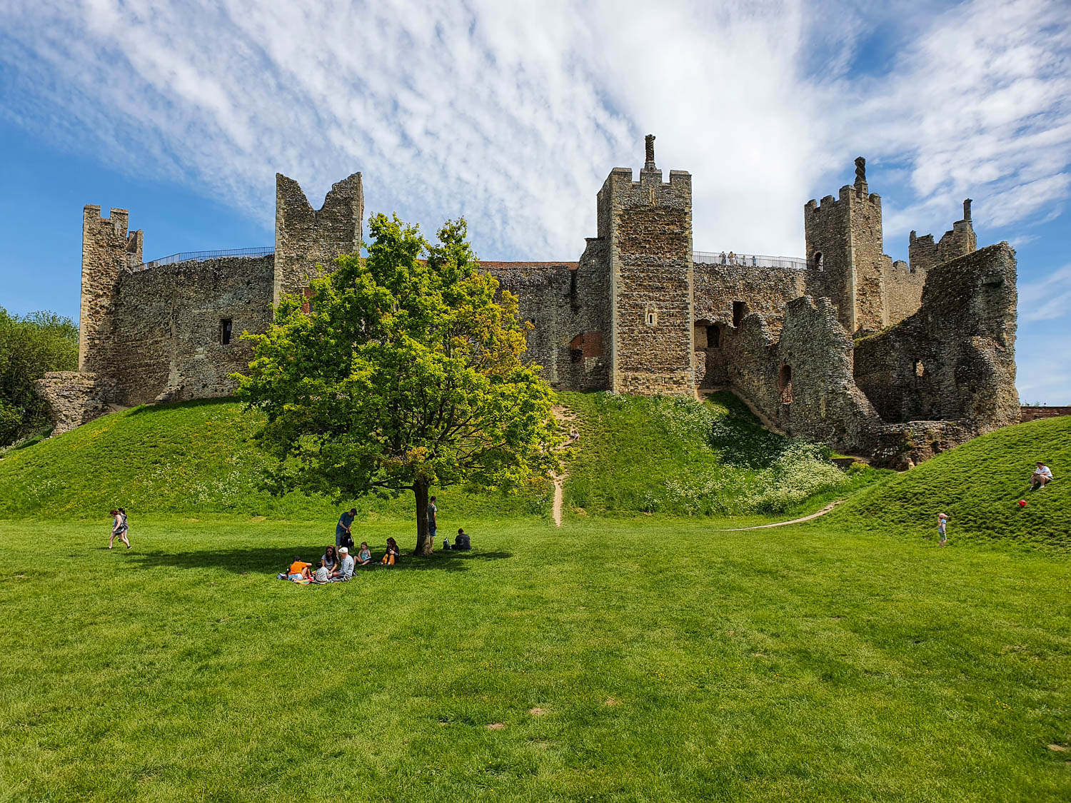 View up to Framlingham Castle on its hill, with its stone towers and some crumbling walls - visiting Framlingham Castle with kids