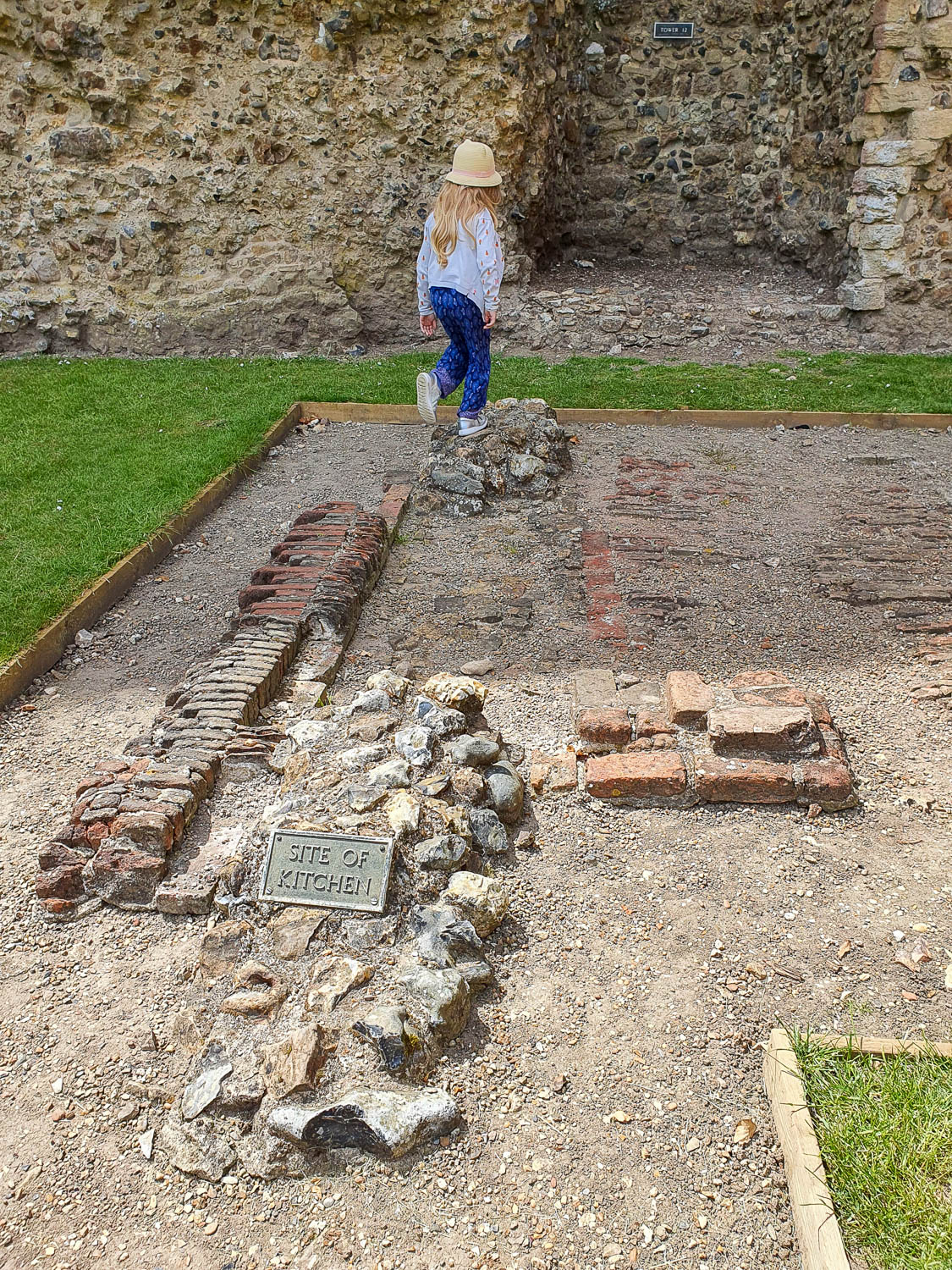 My daughter explores the stones remaining from the old castle kitchens on a day out at Framlingham Castle with kids