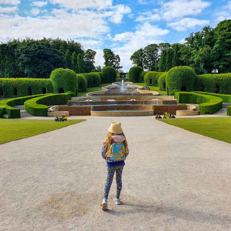 My daughter walks towards the Grand Cascade water feature at the entrance to the Alnwick Garden - one of the great things to do in Northumberland with kids