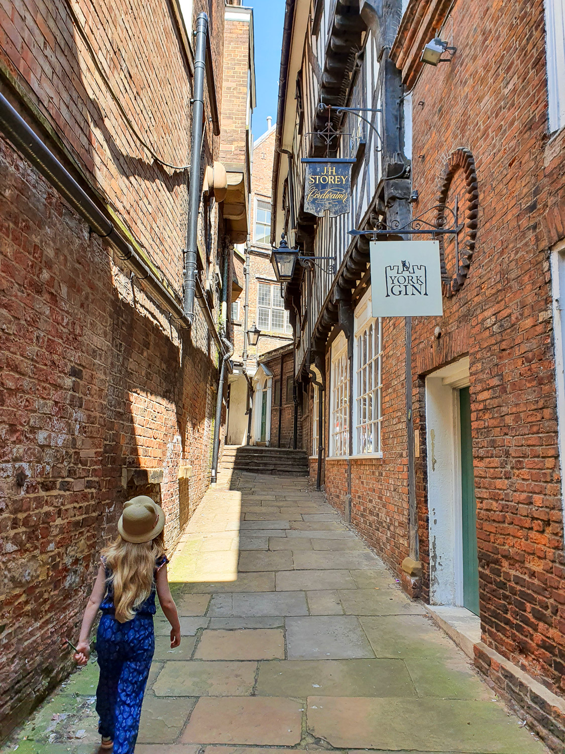 Girl walks through one of the historic alleys in York - finding the best places in York for Harry Potter fans