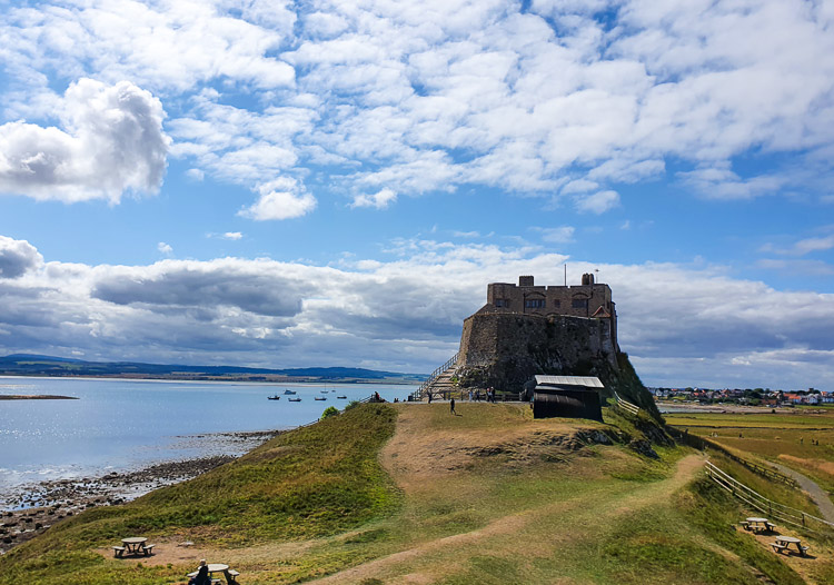 View of Lindisfarne island including the castle and harbour - the best things to do in Lindisfarne with kids on a visit to Holy Island, Northumberland