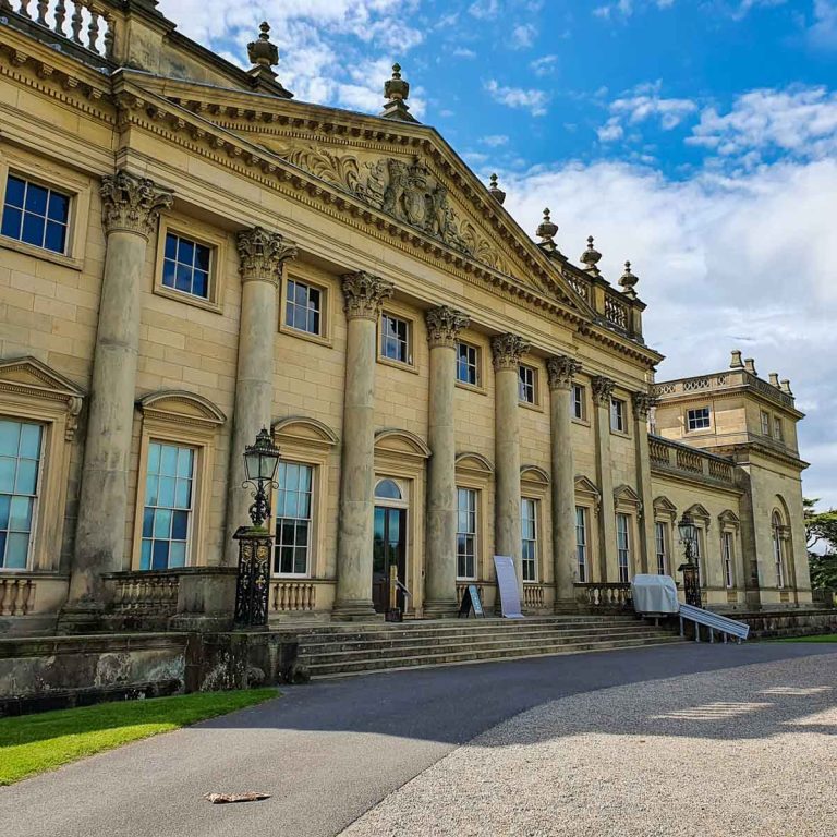 View of the front of Harewood House in Yorkshire against a blue sky - one of my favourite days out with kids in Leeds