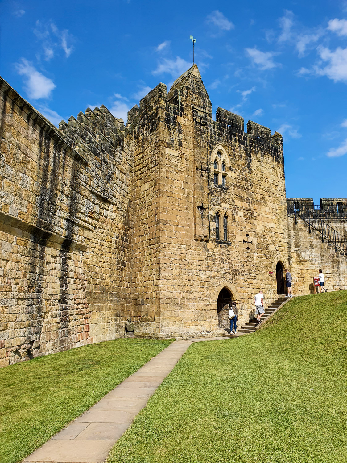View of the Constable Tower and ramparts with steps up to the walls during a day out with kids at Alnwick Castle in Northumberland
